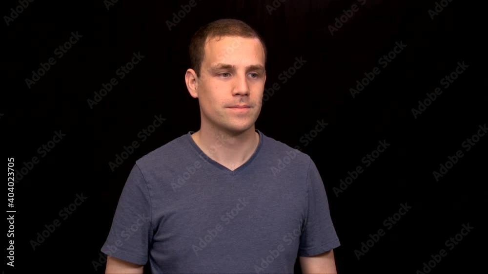 A white caucasian young man is reacting in a studio on black background A white caucasian young man is reacting in a studio on black background