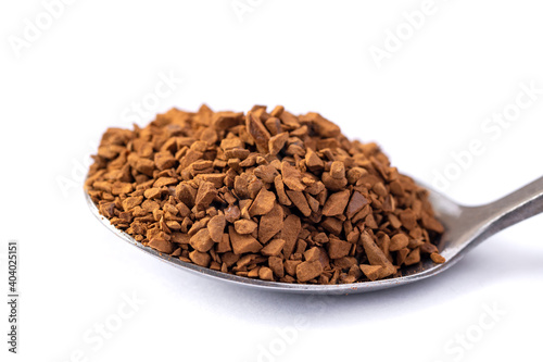 Freeze dried coffee. Metal spoon with granulated Instant Coffee close-up on white