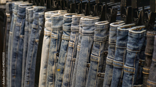 a close up of jeans hanging in a row.