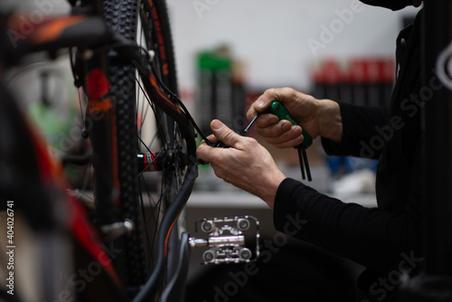 Mechanic fixing rear brake of mountain bike in bike shop