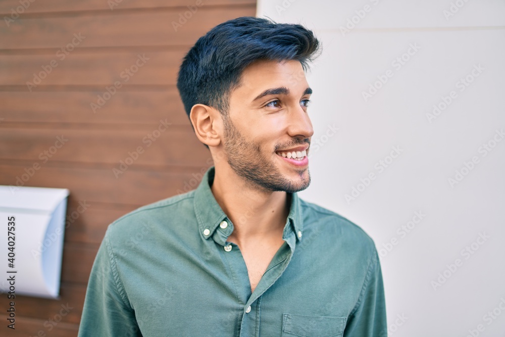 Young latin man smiling happy walking at the city. Young latin man smiling happy walking at the city.
