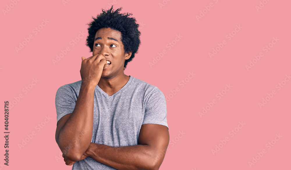 Handsome african american man with afro hair wearing casual clothes looking stressed and nervous with hands on mouth biting nails. anxiety problem.