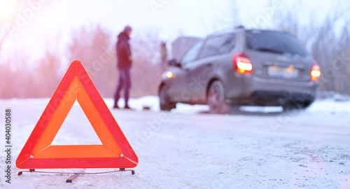 car repair on the road in winter. Car triangle on winter road. Problem with vehicle on snowy road. Broken cars concept. banner of snowy winter road