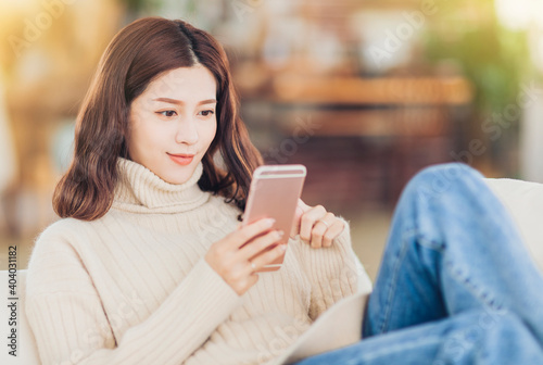 girl sitting on couch and watching smartphone