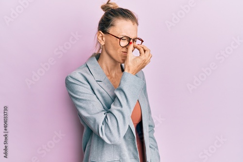 Beautiful caucasian woman wearing business jacket and glasses tired rubbing nose and eyes feeling fatigue and headache. stress and frustration concept.