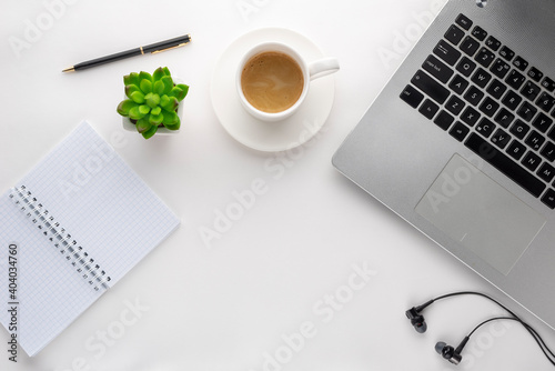 notebook, laptop, pen, flower, cup of coffee on a white surface