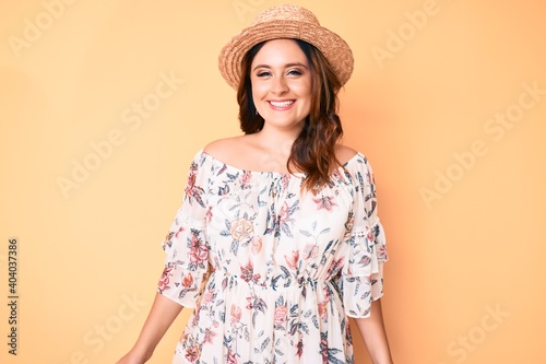 Young beautiful caucasian woman wearing summer dress and hat with a happy and cool smile on face. lucky person.