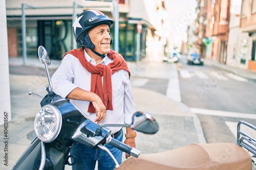 Senior motorcyclist man smiling happy wearing moto helmet at the city. © Krakenimages.com