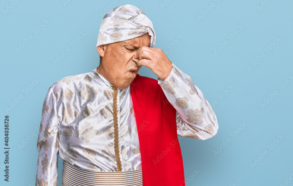 Senior hispanic man wearing tradition sherwani saree clothes tired rubbing nose and eyes feeling fatigue and headache. stress and frustration concept. Senior hispanic man wearing tradition sherwani saree clothes tired rubbing nose and eyes feeling fatigue and headache. stress and frustration concept.