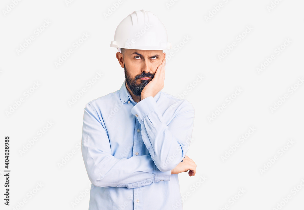 Young handsome man wearing architect hardhat thinking looking tired and bored with depression problems with crossed arms. Young handsome man wearing architect hardhat thinking looking tired and bored with depression problems with crossed arms.