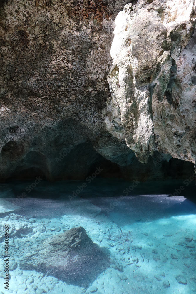 A lake in the depths of a gray cave - gray rocks, rocks and bright blue water 