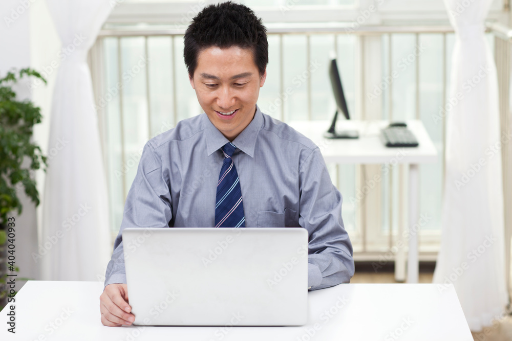 Close-up of a businessman using a laptop in an office Close-up of a businessman using a laptop in an office