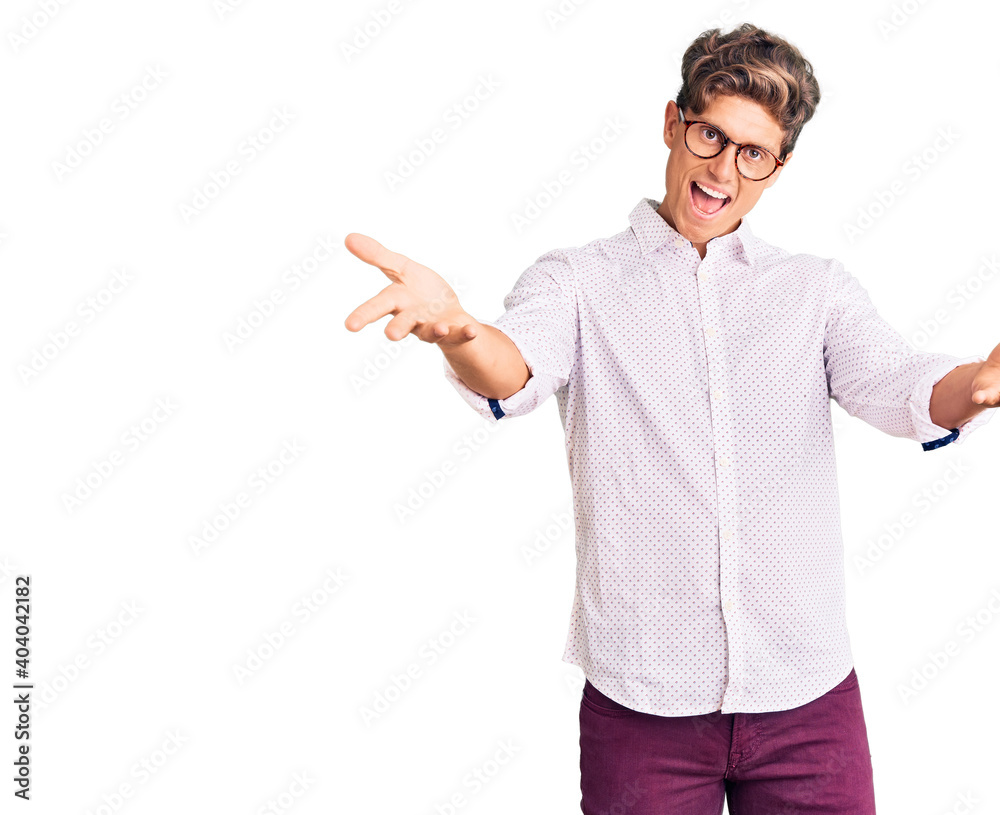 Young handsome man wearing business clothes and glasses smiling cheerful offering hands giving assistance and acceptance. Young handsome man wearing business clothes and glasses smiling cheerful offering hands giving assistance and acceptance.