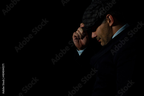 Canvas Print Mysterious english gangster with flat cap and black coat