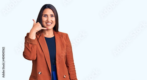 Young beautiful brunette woman wearing elegant clothes smiling doing phone gesture with hand and fingers like talking on the telephone. communicating concepts.