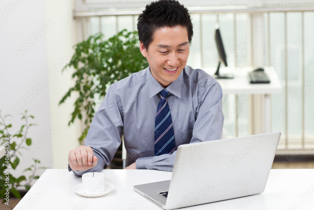 Close-up of a businessman using a laptop in an office Close-up of a businessman using a laptop in an office