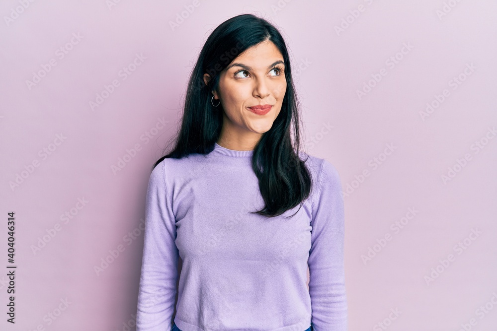 Young hispanic woman wearing casual clothes smiling looking to the side and staring away thinking.