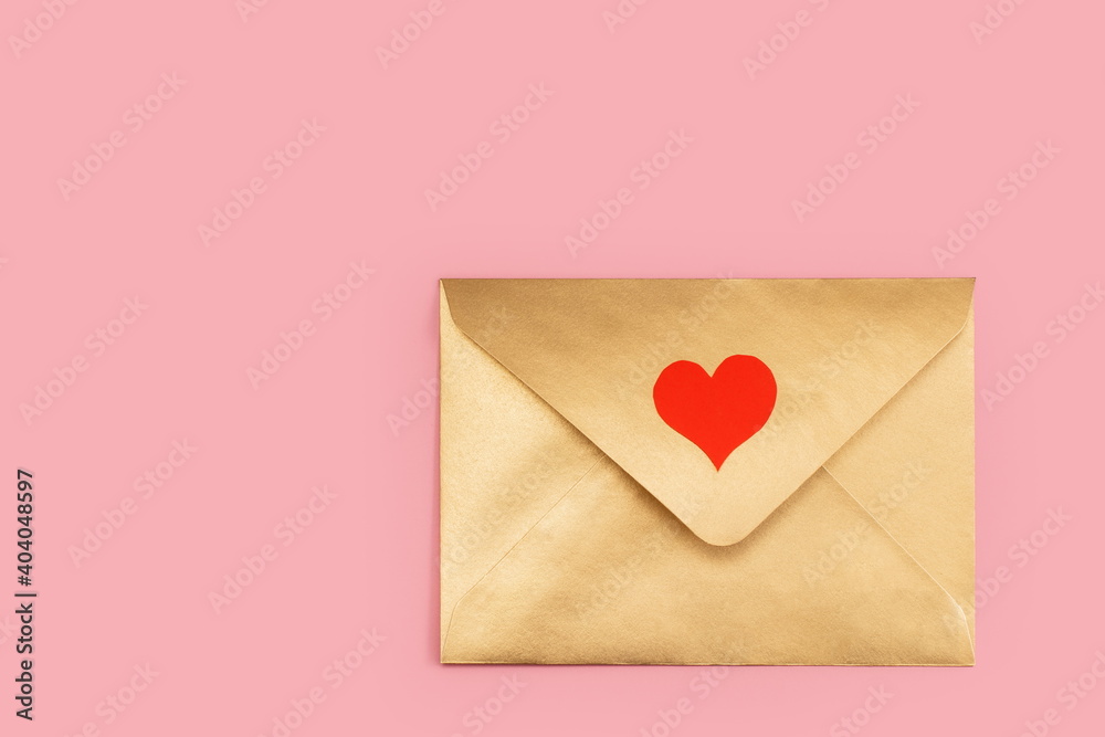 Golden paper envelope with red heart isolated on pink background Golden paper envelope with red heart isolated on pink background