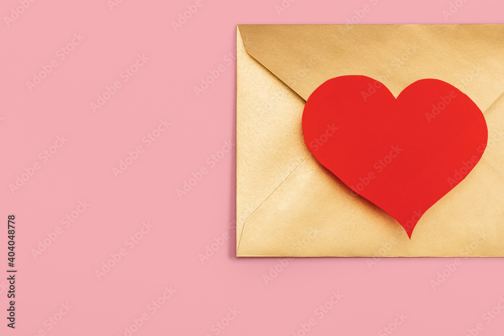 Golden paper envelope with red heart isolated on pink background Golden paper envelope with red heart isolated on pink background