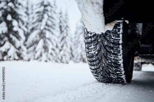 Close-up view of tire of car on snow covered and icy road. Themes safety and driving in winter. © Chalabala
