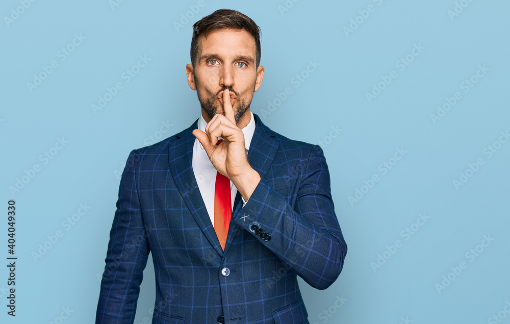 Handsome man with beard wearing business suit and tie asking to be quiet with finger on lips. silence and secret concept. Handsome man with beard wearing business suit and tie asking to be quiet with finger on lips. silence and secret concept.