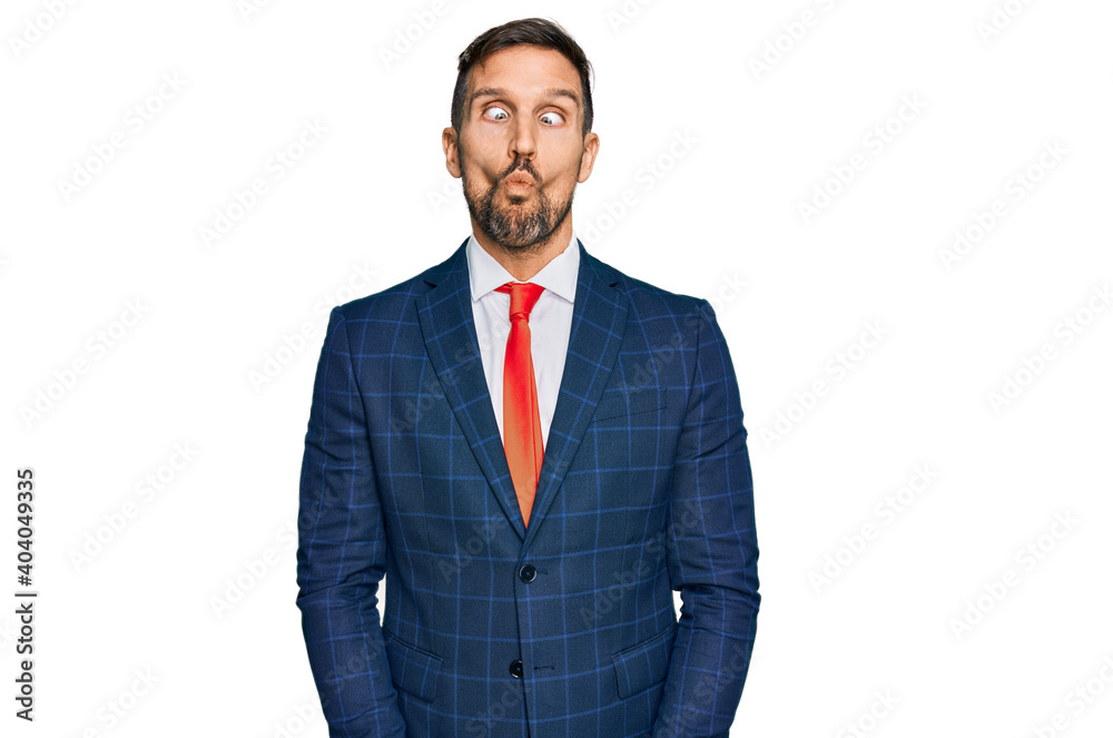 Handsome man with beard wearing business suit and tie making fish face with lips, crazy and comical gesture. funny expression. Handsome man with beard wearing business suit and tie making fish face with lips, crazy and comical gesture. funny expression.
