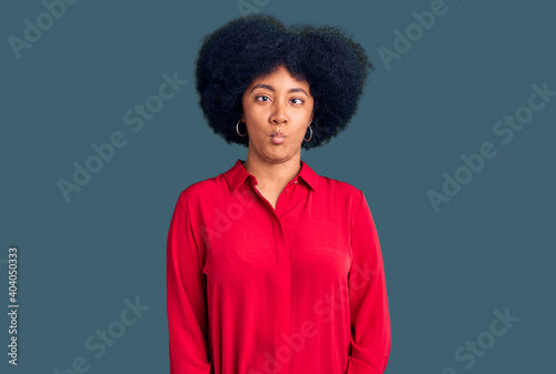 Young african american girl wearing casual clothes making fish face with lips, crazy and comical gesture. funny expression.