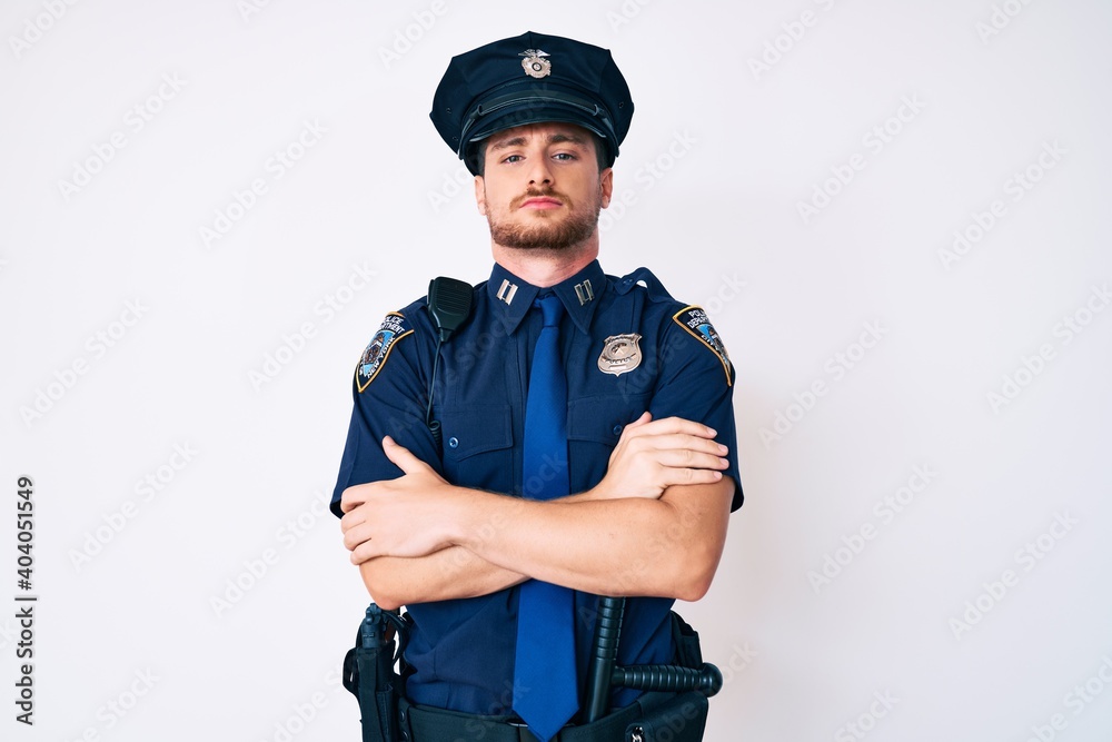 Young caucasian man wearing police uniform skeptic and nervous, disapproving expression on face with crossed arms. negative person. Young caucasian man wearing police uniform skeptic and nervous, disapproving expression on face with crossed arms. negative person.