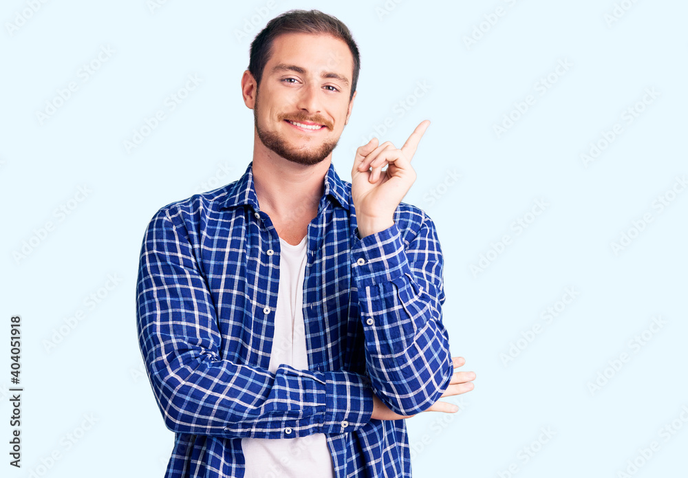 Young handsome caucasian man wearing casual clothes with a big smile on face, pointing with hand and finger to the side looking at the camera. Young handsome caucasian man wearing casual clothes with a big smile on face, pointing with hand and finger to the side looking at the camera.