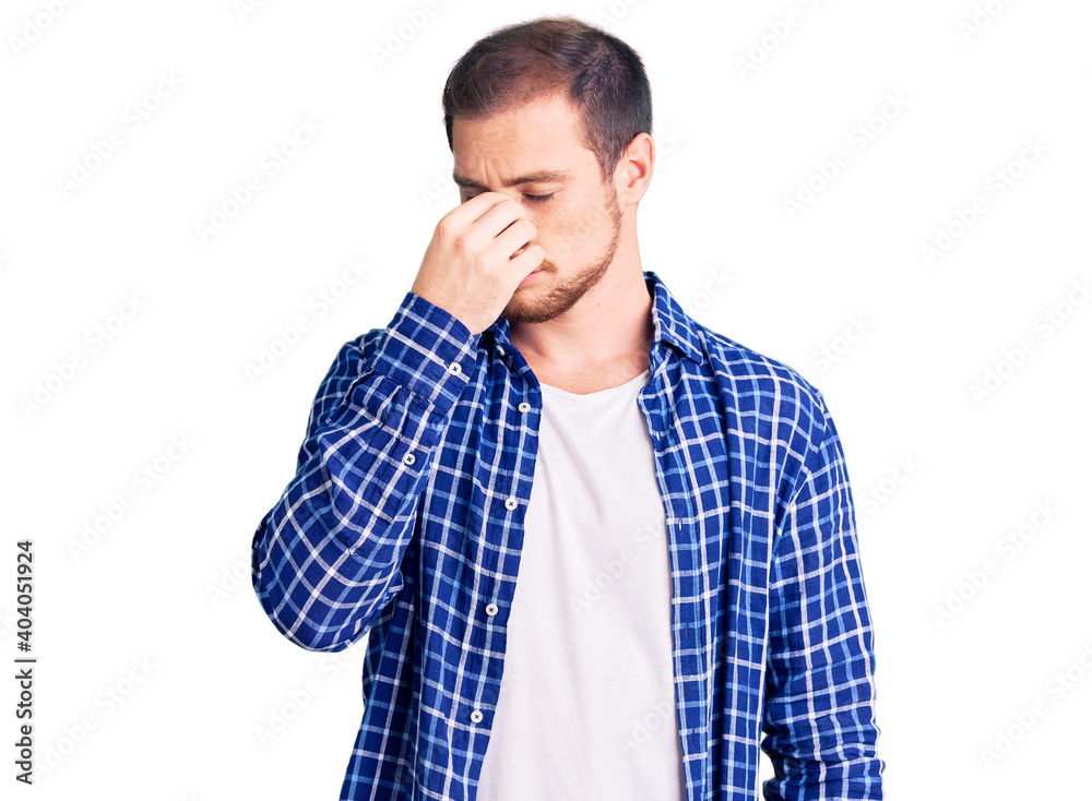 Young handsome caucasian man wearing casual clothes tired rubbing nose and eyes feeling fatigue and headache. stress and frustration concept. Young handsome caucasian man wearing casual clothes tired rubbing nose and eyes feeling fatigue and headache. stress and frustration concept.