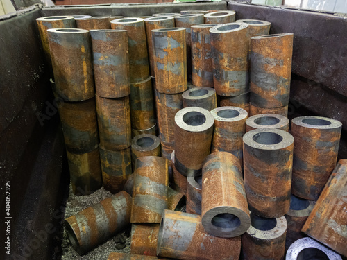 rusted thick steel pipe chunks after sawing in industrial crate waiting for machining operations photo