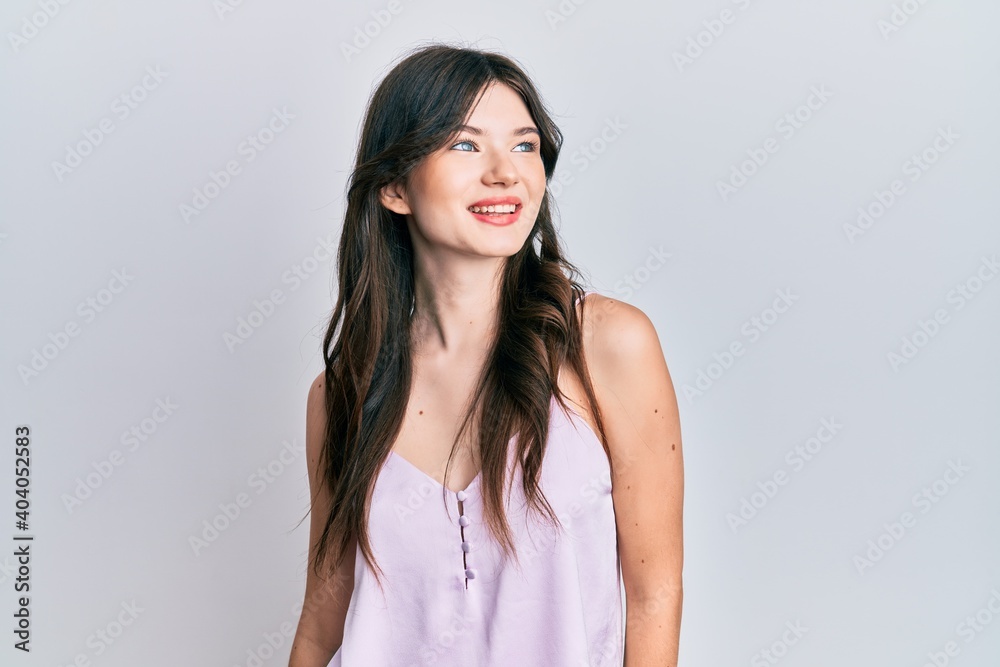 Young beautiful caucasian girl wearing casual clothes looking to side, relax profile pose with natural face and confident smile. Young beautiful caucasian girl wearing casual clothes looking to side, relax profile pose with natural face and confident smile.