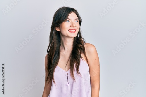 Young beautiful caucasian girl wearing casual clothes looking to side, relax profile pose with natural face and confident smile.