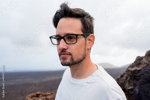 Young man with glasses in a cloudy day