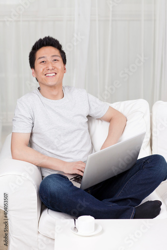 Cheerful businessman using a laptop computer in sofa