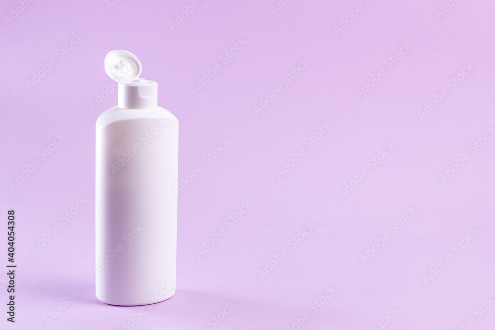 White plastic bottle with cream without label on a lilac background. White plastic bottle with cream without label on a lilac background.