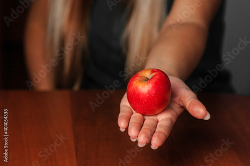 Girl holds an apple in the palm of her hand