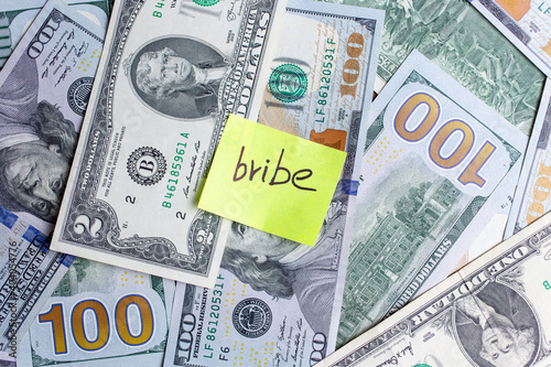 Yellow stick note on an USD money background. The inscription bride on a yellow memory sticky note
