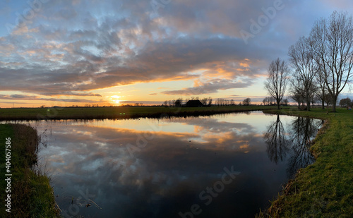 Winter sunset with clouds reflection in a lake