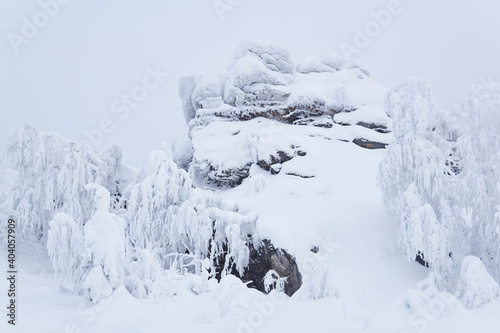 snow-covered rock and frosty trees on a mountain pass in winter