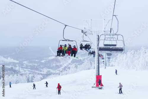 chairlift and downhill skiers in a winter hilly landscape