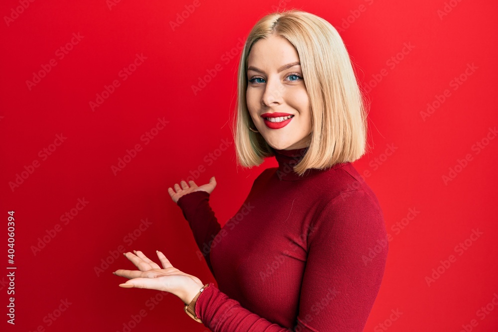 Naklejka premium Young blonde woman wearing casual clothes inviting to enter smiling natural with open hand