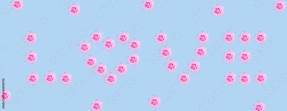 Valentine's Day banner background. Love word laid out of pink roses on pastel blue background with copy space.