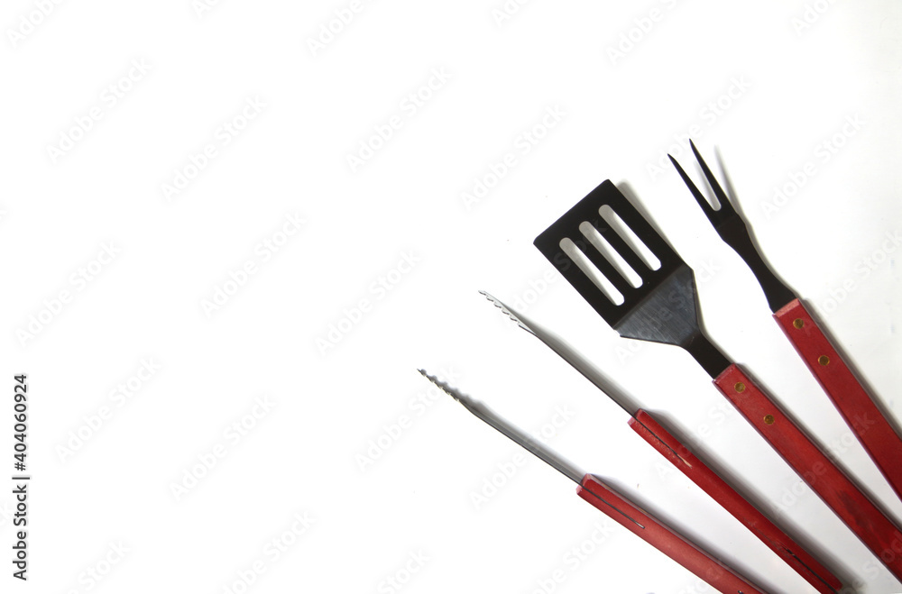 BBQ instruments kit - tongs, spatula, fork - close up isolated on white background flat lay BBQ instruments kit - tongs, spatula, fork - close up isolated on white background flat lay