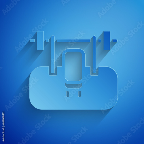 Paper cut Bench with barbel icon isolated on blue background. Gym equipment. Bodybuilding, powerlifting, fitness concept. Paper art style. Vector.