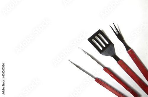 BBQ instruments kit - tongs, spatula, fork - close up isolated on white background flat lay