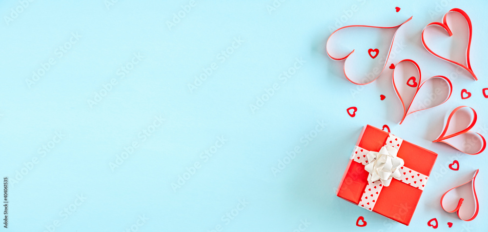 Hand made red paper hears, red gift box, confetti on blue background, top view, copy space, romantic Valentines concept Hand made red paper hears, red gift box, confetti on blue background, top view, copy space, romantic Valentines concept