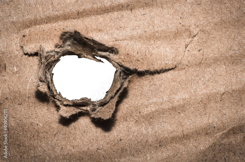 Closeup of torn paper hole on white background with space for your text.
