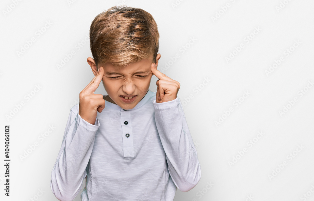 Little caucasian boy kid wearing casual clothes with hand on head for pain in head because stress. suffering migraine. Little caucasian boy kid wearing casual clothes with hand on head for pain in head because stress. suffering migraine.