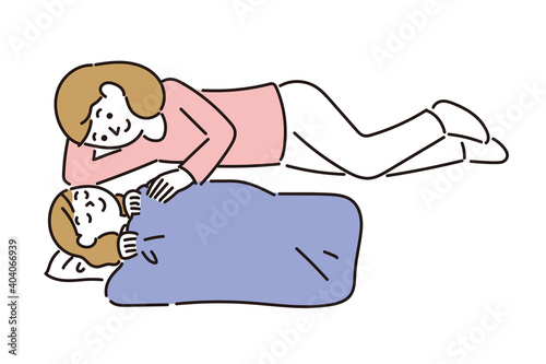 母親に添い寝され安心して眠る女の子